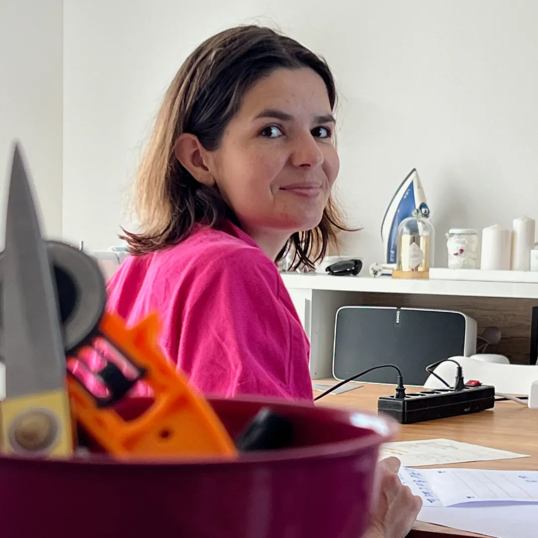 Nina souriante dans son atelier, entourée de créations
